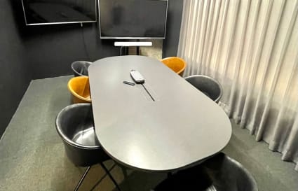 Sleek meeting space with modern seating, dual screens, and ambient lighting in Chai Wan Kok.