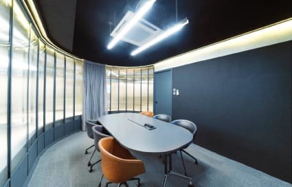 Sleek meeting room with modern lighting, curved glass walls, and stylish seating in Chai Wan Kok.