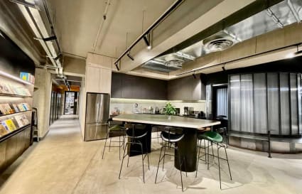 Modern coworking kitchen with sleek finishes, ample seating, and abundant natural light.