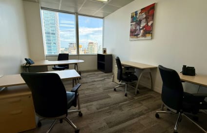 Modern coworking space with a city view, ergonomic chairs, and natural lighting.