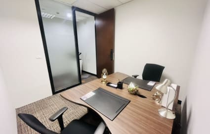 Modern private office with sleek furniture, ample lighting, and frosted privacy glass.