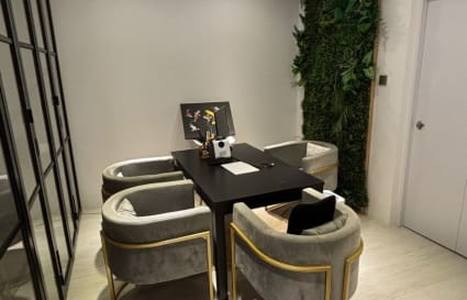 Elegant meeting space with modern chairs, green accent wall, and warm lighting in North Bridge Road.
