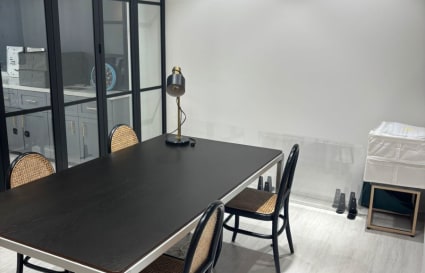 Contemporary coworking space with sleek table, natural lighting, and quiet ambiance.