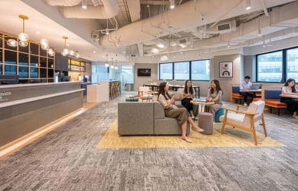 Modern coworking space with open layout, natural light, and stylish seating in Raffles Place.