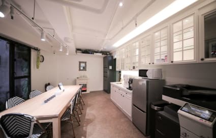 Modern coworking space with sleek kitchen amenities and collaborative seating. Ideal for meetings.