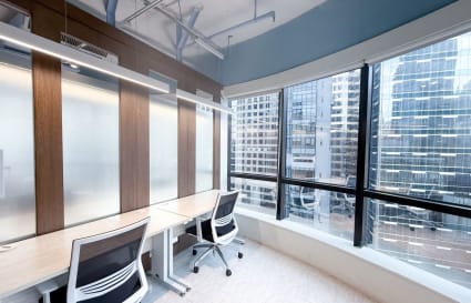 Bright coworking space with city views, ergonomic chairs, and sleek workstations on Wellington Street.
