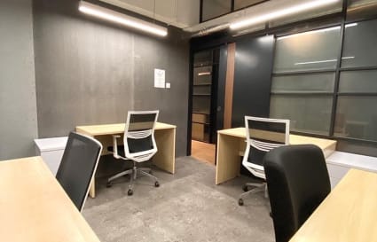 Modern coworking space with ample natural light, ergonomic chairs, and sleek desks.