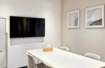 Sleek meeting room with modern decor and presentation tools in a flexible coworking space.