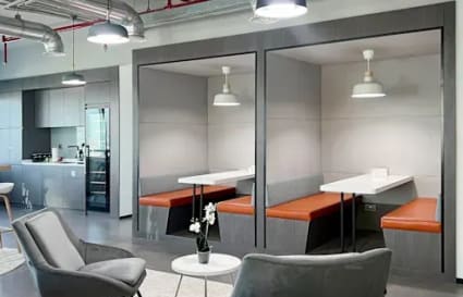 Modern coworking space with cozy seating, stylish booths, and ample lighting in DMCC Free Zone.