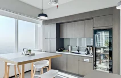 Bright, modern kitchenette with ample natural light, sleek cabinetry, and a communal table. Perfect for collaboration.