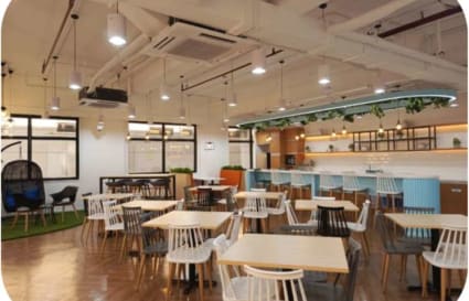 Bright and modern coworking space with versatile seating and a stylish kitchen area.
