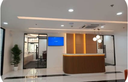 Sleek coworking space with modern reception, ambient lighting, and glass-enclosed meeting rooms.