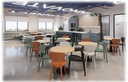 Bright coworking space with modern furniture, natural light, and kitchen area. Ideal for collaboration.