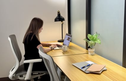 Modern coworking desk with ergonomic chair, ambient lighting, and natural accents.