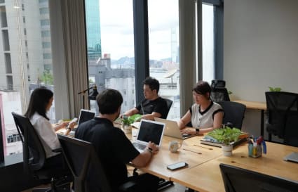 Bright coworking space with large windows, modern desks, and city views on Jaffe Road.