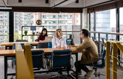 Bright coworking space with modern furniture and city views, perfect for collaboration and focus.