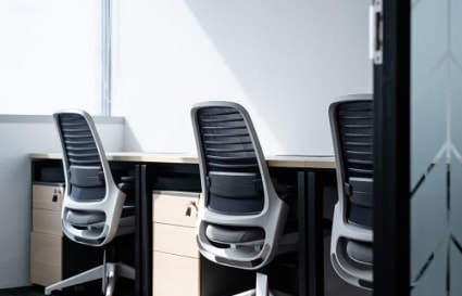 Bright and modern workspace with ergonomic chairs and ample natural light.