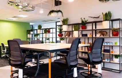Modern coworking space with vibrant decor, ergonomic seating, and abundant natural lighting.