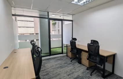 Modern coworking space with natural light, ergonomic chairs, and sleek desks on Orchard Road.