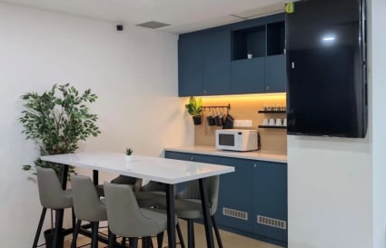 Sleek kitchenette with bar seating, perfect for casual meet-ups in Orchard Road coworking space.