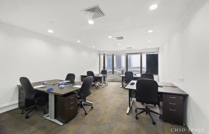 Spacious coworking area with modern desks, ergonomic chairs, and expansive city views.