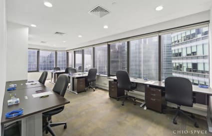 Bright coworking space with city views, modern desks, and ample natural light.
