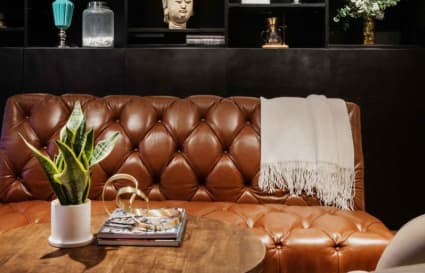 Cozy coworking lounge with a leather sofa, elegant decor, and inviting atmosphere.