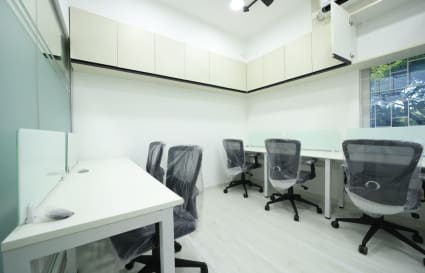 Modern coworking space with ergonomic chairs, ample natural light, and sleek workstations.