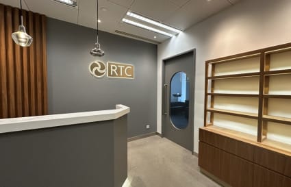 Chic coworking reception with modern lighting and sleek shelving, perfect for professionals.