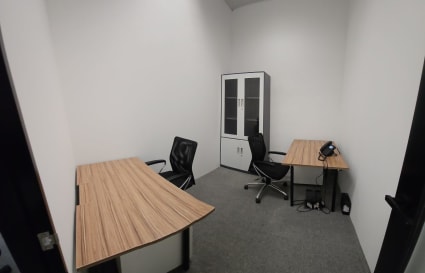 Compact and private office with modern desks, chairs, and a storage cabinet. Perfect for focused work.