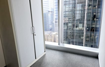 Bright coworking space with floor-to-ceiling windows and city views on How Ming Street.