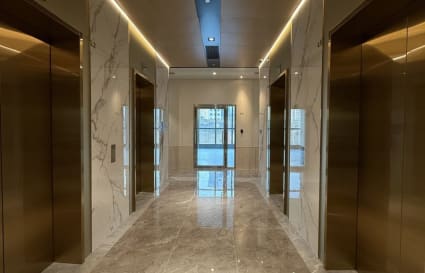 Modern coworking space with elegant marble flooring and sleek elevator access.