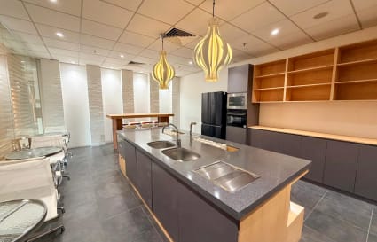 Modern coworking kitchen with sleek countertops and elegant lighting in Kowloon. Ideal for collaboration.