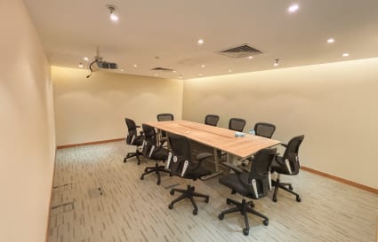 Modern conference room with ergonomic chairs and ceiling projector, ideal for meetings.