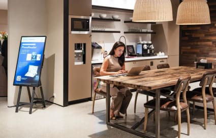 Modern coworking space with cozy seating, coffee bar, and warm lighting for a productive workday.