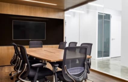 Modern meeting room with sleek wood paneling and ergonomic chairs. Ideal for dynamic teams.
