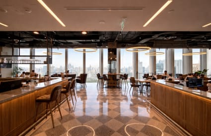 Stylish coworking space with city views, ample seating, and modern lighting in Bang Rak, Bangkok.