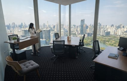 Bright coworking space with panoramic city views and modern furnishings in Bang Rak, Bangkok.