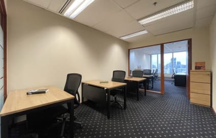 Modern coworking space with ergonomic chairs, ample natural light, and city views.