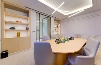 Elegant conference room with modern design, ample natural light, and stylish shelving. Perfect for meetings.