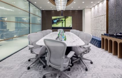 Modern conference room with sleek marble table, ergonomic chairs, and vibrant lighting.