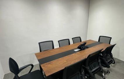 Modern meeting room with sleek table and ergonomic chairs, ideal for collaborative sessions.