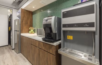 Modern kitchenette with coffee machine and fridge; perfect for coworking breaks in Kowloon.