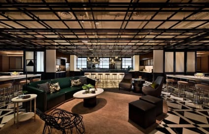 Modern coworking lounge with stylish seating, contemporary lighting, and a sleek open design.