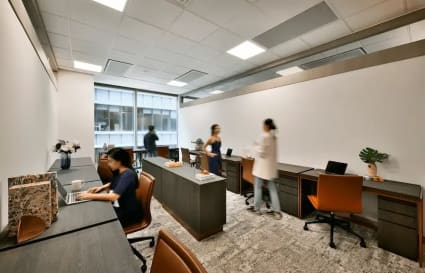 Modern coworking space with natural light, ergonomic chairs, and collaborative workstations.