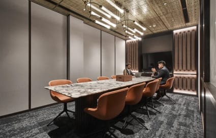 Elegant meeting room with marble table, modern lighting, and plush seating for a refined workspace.