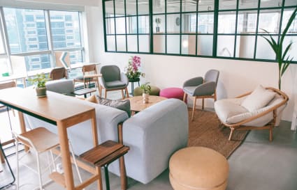 Modern coworking space with cozy seating, natural light, and greenery in Hong Kong Island.