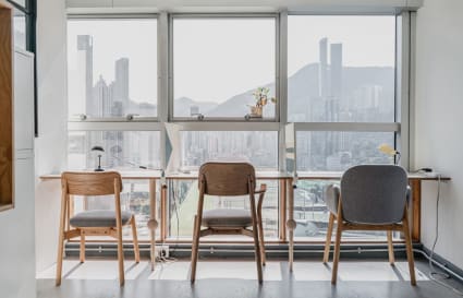 Bright coworking space with stunning city views, modern furniture, and ample natural light.