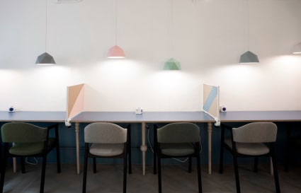 Modern coworking desks with warm lighting and privacy dividers in Wan Chai.