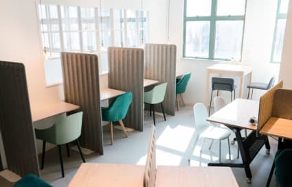 Bright coworking space with privacy dividers and modern seating on How Ming Street, Kowloon.